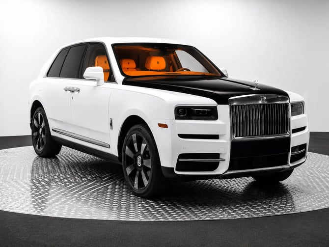 White luxury SUV with black hood and orange interior seats on display platform