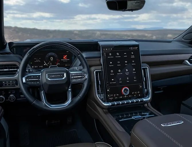 Modern truck interior with steering wheel, digital dashboard, and touchscreen display overlooking mountainous landscape